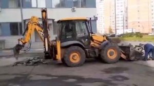Ремонт и замена асфальта во дворе жилого дома. Трактор-погрузчик