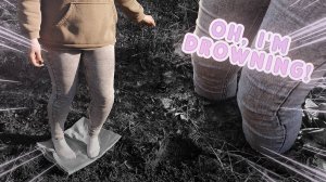 Девушка в джинсах и белых носочках ходит по грязи