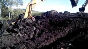 Экскаватор вытаскивает застрявший экскаватор зацепившись ковшами