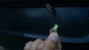 Замена лампы номерного знака Opel Astra J