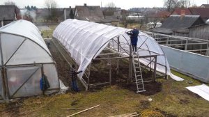 Накрываем  арочную теплицу пленкой.Ширина пленки 12 метров, длина теплицы 26 метров.