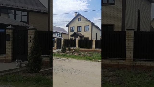 Вариант фасада кирпичного двухэтажного дома с забором и навесом под автомобиль