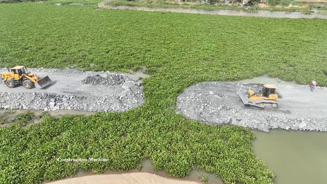 Смычка двух участков насыпной дороги. Бульдозер и фронтальный погрузчик соединяют части грунтовки смотреть онлайн