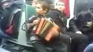 Мальчик поёт песни в электричке.