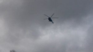 Вертолёт низко летит над кораблями.