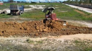 Бульдозер Komatsu D20P работает, у глубокого водоема