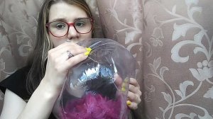 Симпатичная девушка тренирует лёгкие, надувая пляжный мяч