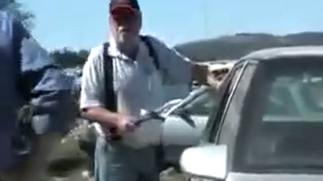 репортер пытается разбить молотком стекло