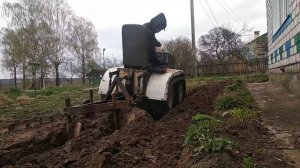 Гусеничный минитрактор пашет огород .