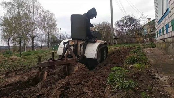 Гусеничный минитрактор пашет огород .