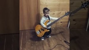 Маленький мальчик играет на бас- гитаре