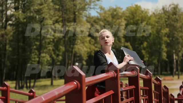 Young beautiful girl reading a book in a green Park on the bridge. Blonde hair смотреть онлайн