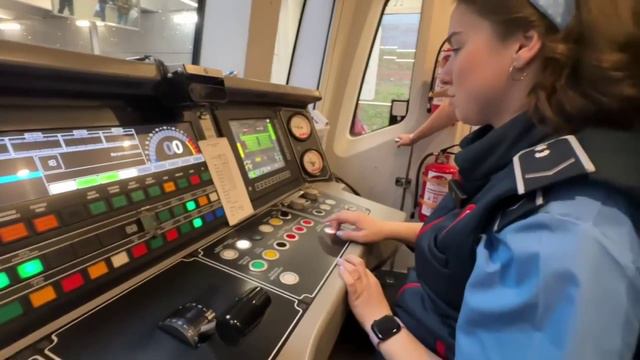 Женщина работает машинистом метро.