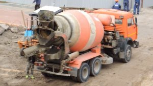 Автобетоносмеситель едет, чтобы промыться от раствора.