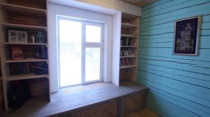 Окно с большим подоконником и полками для книг.