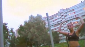 Девушка-турникмен в коротких шортах показывает упражнения на турнике. Воркаут