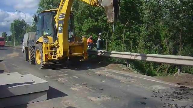 Гидромолот Komatsu WB 93s в Калуге производит демонтаж дорожного полотна. смотреть онлайн