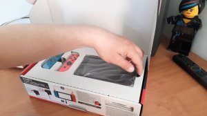 распаковка Nintendo Switch 2-ой ревизии на фоне первой консоли Nintendo