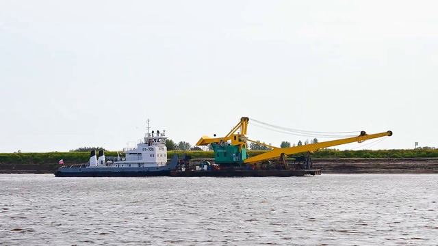 Лодка-толкач буксирует баржу с краном. Сургут, Россия смотреть онлайн