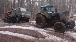 Трактора пытаются вытащить застрявшие грузовики.