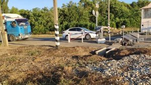 Железнодорожный переезд на котором есть барьер, шлагбаум и семафор.