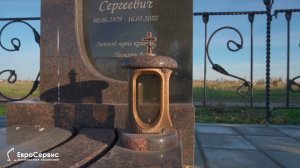 Гранитный памятник комбинированный, из двух видов камня. Выложена тротуарная плитка. Ограда.