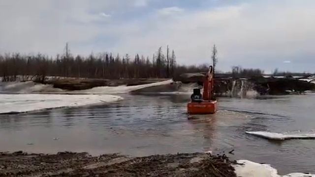 Экскаватор переезжает речку