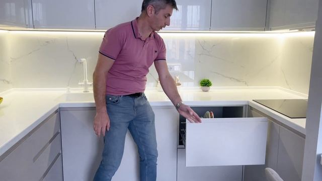 Высокая светлая П образная кухня cо встроенными ручками из эмали глянцевой сверху и матовой снизу. смотреть онлайн
