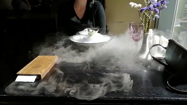 Подача мороженого с сухим льдом в ресторане. Serving ice cream with dry ice in a restaurant