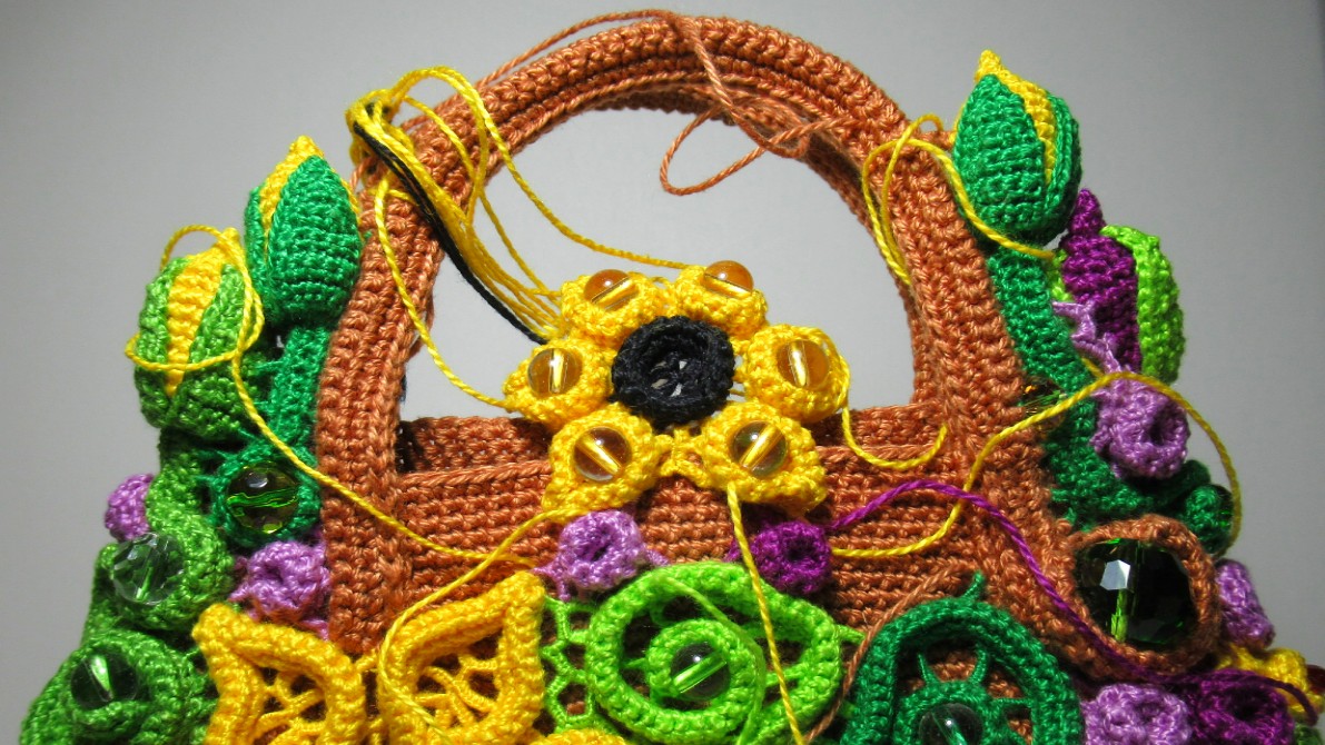 Закрепляю нижние лепестки подсолнуха на поверхности основания вязаной крючком сумки смотреть онлайн