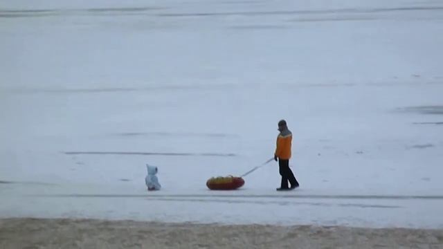 Папа гуляет с ребенком. Катает по льду=)