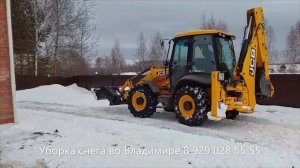 Экскаватор погрузчик трактор JCB чистит снег