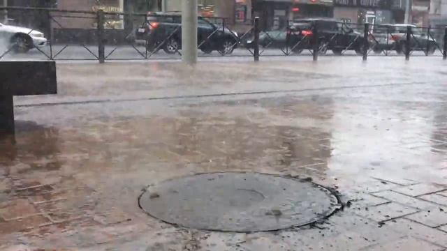 У ТЦ "Кловер" капли дождя заставляют подпрыгивать крышку канализационного люка смотреть онлайн