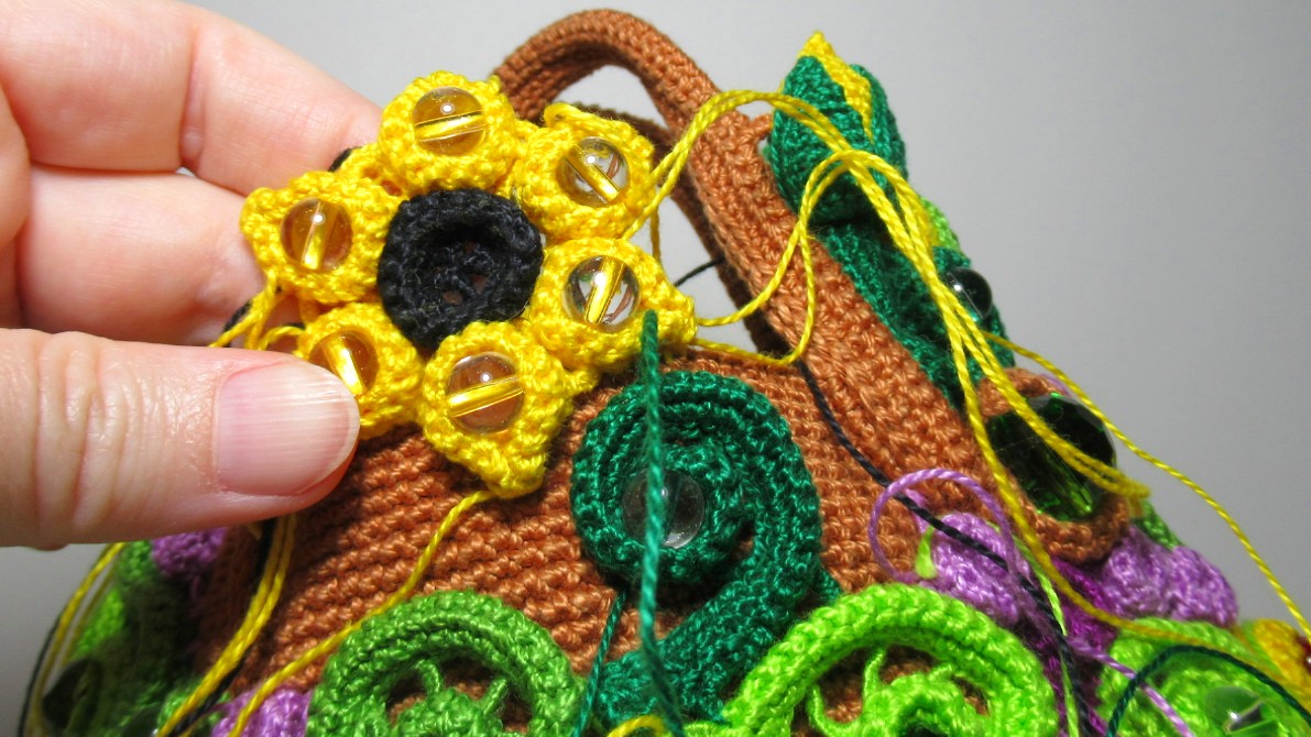 Начинаю добавлять вязаные элементы рядом с застёжкой на обратной стороне вязаной сумки смотреть онлайн