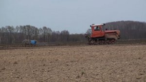 Боронование почвы трактором ДТ 75М с сцепкой из 40 борон.