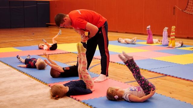 Юные гимнасты вместе с тренерами отрабатывают базовые упражнения. смотреть онлайн