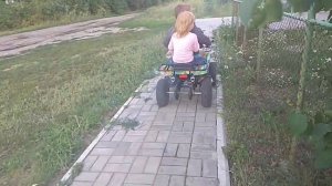 Дети катаются на квадрике по улице (август 2020)