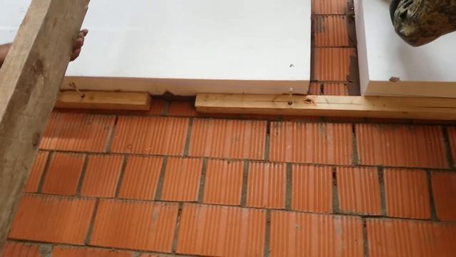 Подгонка листов пенопласта вовремя приклейки под трёхметровое правило, выравниваем фасад дома