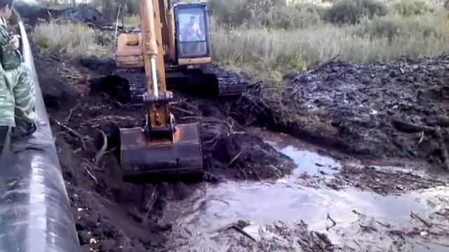 Разработка траншеи в болте, экскаватор делает себе лафет из бревна