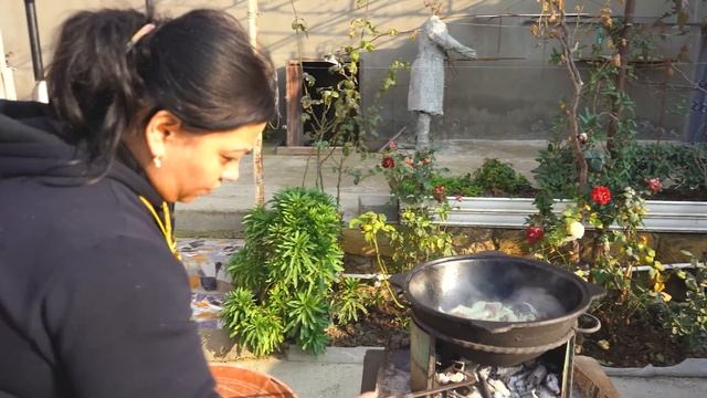 Azerbaijani Woman Cooking Uzbek Pilaf On A Fire In The Village Outdoors