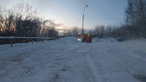 Минипогрузчик чистит снег,