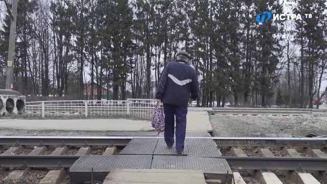 Деревянная железная дорога, люди среди машин. Будет ли ремонт переезда и платформы в Новопетровском смотреть онлайн