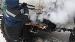 Мойка трактора Т-150К парогенератором на улице зимой.