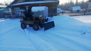 Маленький бульдозер чистит снег