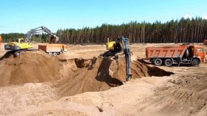 Экскаваторы грузят песок в самосвалы. Excavator loading sand.
