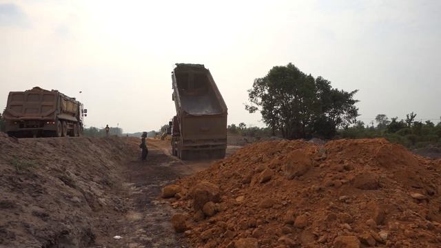 Fantastic old Komatsu dozer with Daewoo 25ton dump truck unloading new road construction at rural смотреть онлайн