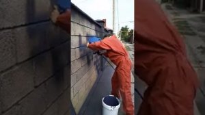 Нанесение каменной краски на забор из блоков