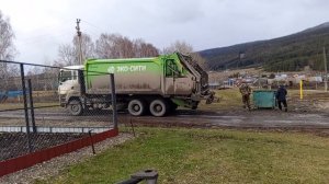 Мусоровоз выгружает мусорный бак