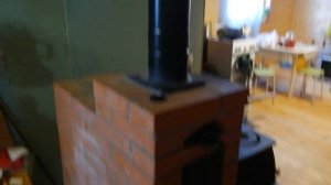 Печь чугунная Бахта с отопительным щитком из кирпича.