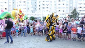 Роботы трансформеры танцуют на празднике для детишек. Главный гость Оптимус Прайм